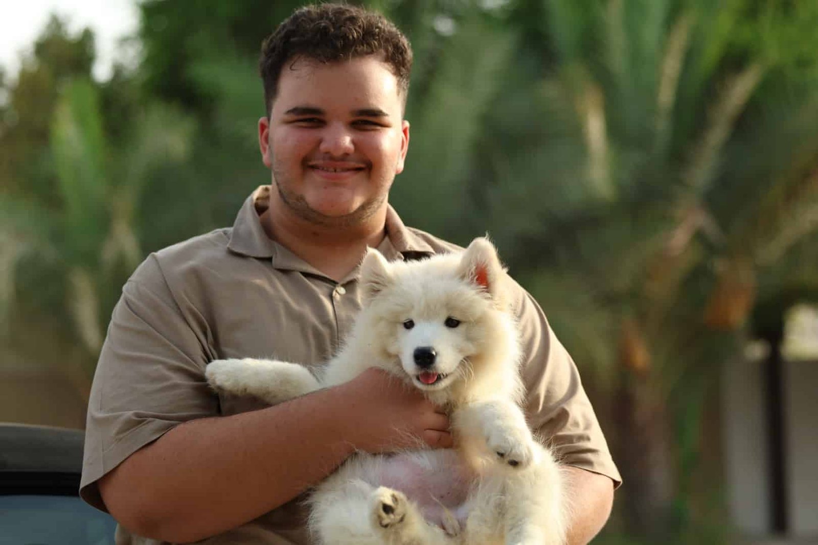 Happy customer holding their new puppy from PuppiesHub